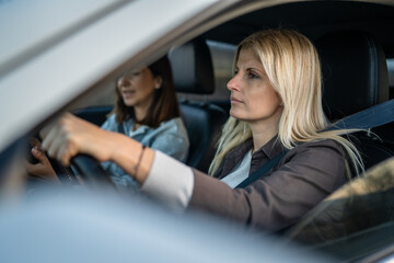 two women drive in a car travel mature caucasian female friends