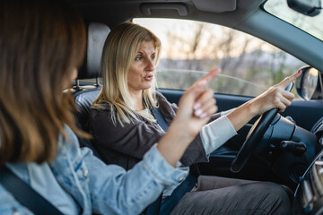 two women drive in a car travel mature caucasian female friends