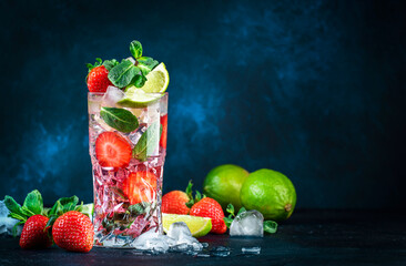 Strawberry Mojito cocktail drink with lime, white rum, soda, cane sugar, mint, and ice in glass on...