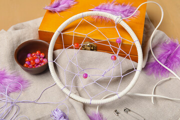 Materials for making dream catcher on beige wooden background, closeup