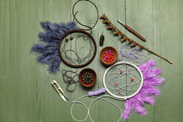 Materials for making dream catchers on green wooden background