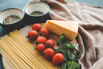 Italian food cooking-tomatoes, basil, pasta and cheese on stone background, top view, copy space