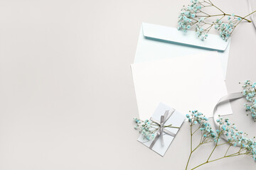 Composition with blank card, envelopes and beautiful gypsophila flowers on white background