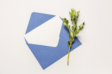 Envelope with blank card and plant branch on white background