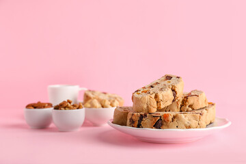 Plate with delicious biscotti cookies on pink background