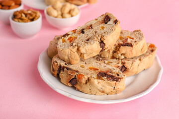 Plate with delicious biscotti cookies on pink background