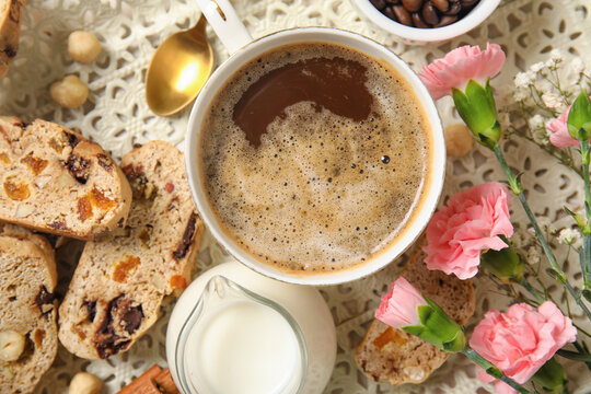 Tray with delicious biscotti cookies, eustoma flowers and cup of coffee, closeup