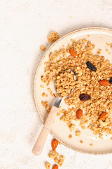 Plate with tasty granola on light background, closeup