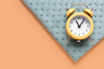 Notebook and alarm clock on color background