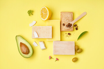 Composition with soap bars and natural ingredients on yellow background