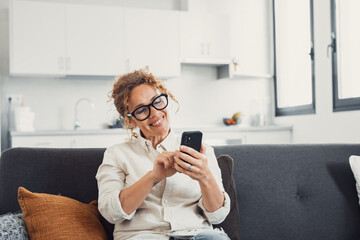 Excited happy young adult woman reading message on mobile phone, getting good news on screen, smiling, laughing, talking on video call, chatting on Internet, using online app. Communication concept.