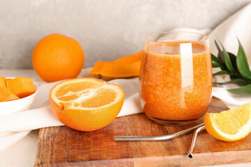 Glass of healthy smoothie and ingredients on light background