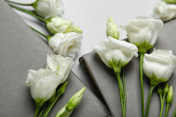 Composition with books and beautiful eustoma flowers on light background, closeup