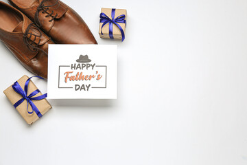 Card with text HAPPY FATHER'S DAY, stylish male shoes and gifts on white background