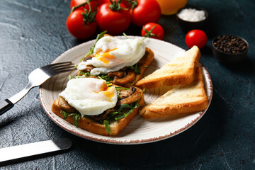 Plate with tasty eggs Benedict on black background