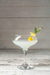 Glass of martini with lemon on wooden table
