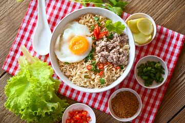noodles bowl with boiled egg minced pork vegetable spring onion lemon lime lettuce celery and chili on table food , instant noodles cooking tasty eating with bowl - noodle soup