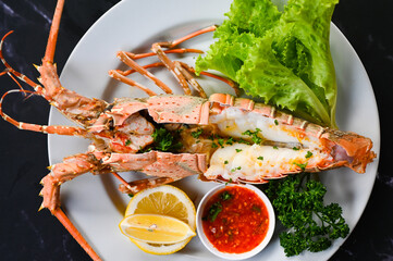 spiny lobster food on plate, fresh lobster or rock lobster seafood with herb and spices lemon...