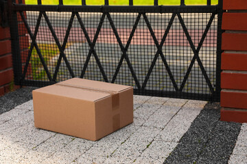 Fototapeta na wymiar Cardboard boxes near front gates outdoors. Parcel delivery service