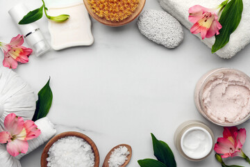 Frame made of different cosmetic products on white marble table, flat lay and space for text. Spa composition