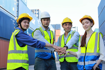 Group of multiethnic technician engineer and businessman in protective uniform standing and discussing, researching, brainstorming and planning work together with tablet at container cargo site