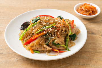 japchae or stir-fried Korean vermicelli noodles with vegetables and pork topped with white sesame