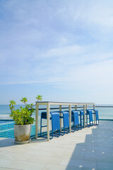 desk and bar stool near swimming pool with sea background