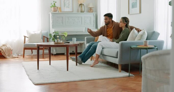 Happy couple, coffee and watch a movie in the living room of their home or house. Love, romance and relax man and woman streaming online series while watching tv subscription together on the sofa