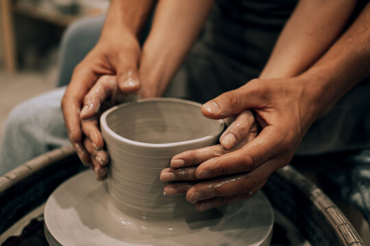 Couple mold ceramic vase in a pottery workshop, hands close up. - Powered by Adobe