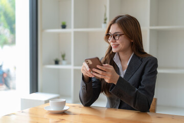 A woman checks her mobile phone while having a cup of coffee. Concept of work and social networks.