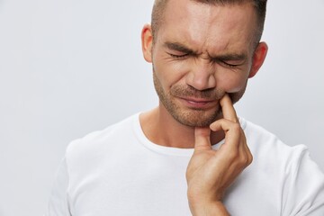 Man toothache, wisdom tooth gum inflammation, in white T-shirt on white isolated background, copy...