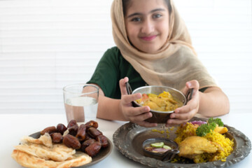 Obraz na płótnie Canvas Child Muslim girl showing curry and chicken Biryani, Muslim yellow rice with chicken, Halal food, selective focus