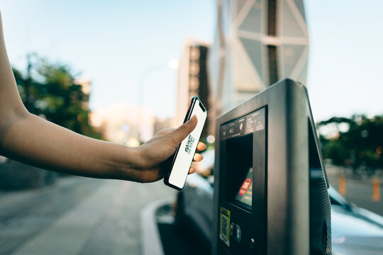 Business woman paying for parking using mobile phone