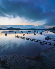 Soft and hazy aerial sunrise waterscape with boats