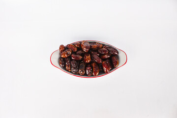 A bowl of dates isolated on a white background, with top view