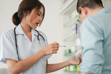 Medicine and health concept, Female pharmacist hold pill bottle to explaining medication for client