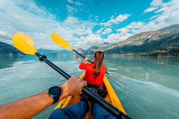 kayaking in Squamish paddling in kayak in Howe Sound a fjord surrounded by mountains. People living...