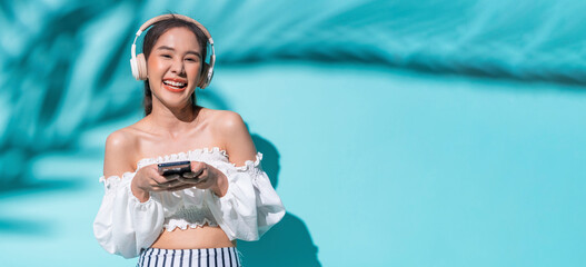 delight freshness asia woman hand using smartphone application device choosing song for headphone listen,summer vacation woman smiling enjoy day time of summer travel studio shot on colour background,