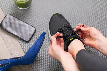 Woman changing high heels to sport running shoes. Exercise after office, healthy living concept. 