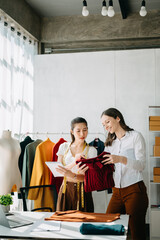 Diverse female fashion designers at work with tailor centimeters on necks and holds tablet and smartphone. independent creative design business. .