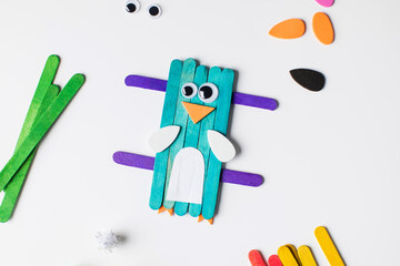 Children's funny craft made of wooden sticks and paper in the form of a bird. Children's creativity