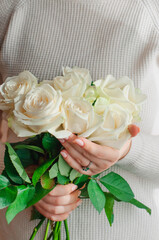the girl's hands hold a bouquet of white roses, congratulations, a place for text. High quality photo