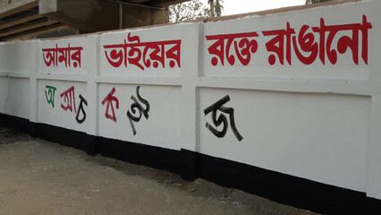 International mother language day celebration calligraphy on a wall. Colorful Bengali calligraphy and alphabets on a white wall. Language movement day slogan Bengali calligraphy design.