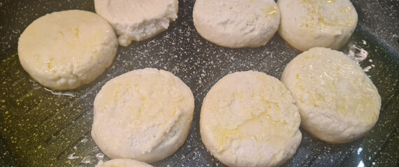 Cooking process and cheesecakes in frying pan in kitchen