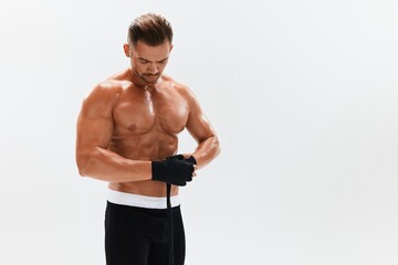 Man athletic bodybuilder poses in boxing gloves with nude torso abs in full-length background, boxing and martial arts. Advertising, sports, active lifestyle, competition, challenge concept. 
