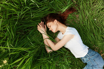 serene, woman lies in green tall grass in casual clothes