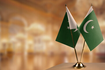 Small flags of the Pakistan on an abstract blurry background