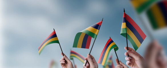 A group of people holding small flags of the Mauritius in their hands