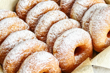 Doughnuts with powdered sugar on a tray, selective focus. Delicious homemade donuts, close-up. A traditional Hanukkah treat. The concept of celebrating Hanukkah. A place to copy.