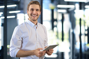 Handsome businessman using his tablet in the office.